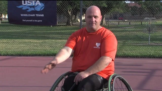 david sitting in tennis wheelchair talking at camera